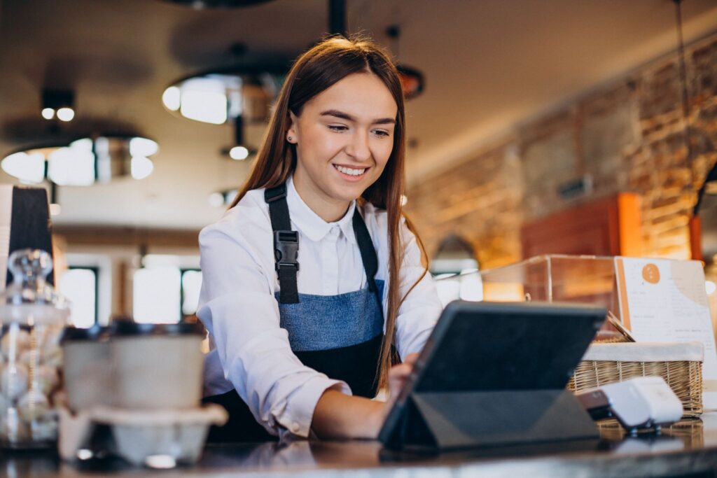 Lady looking at a screen in her restaurant 